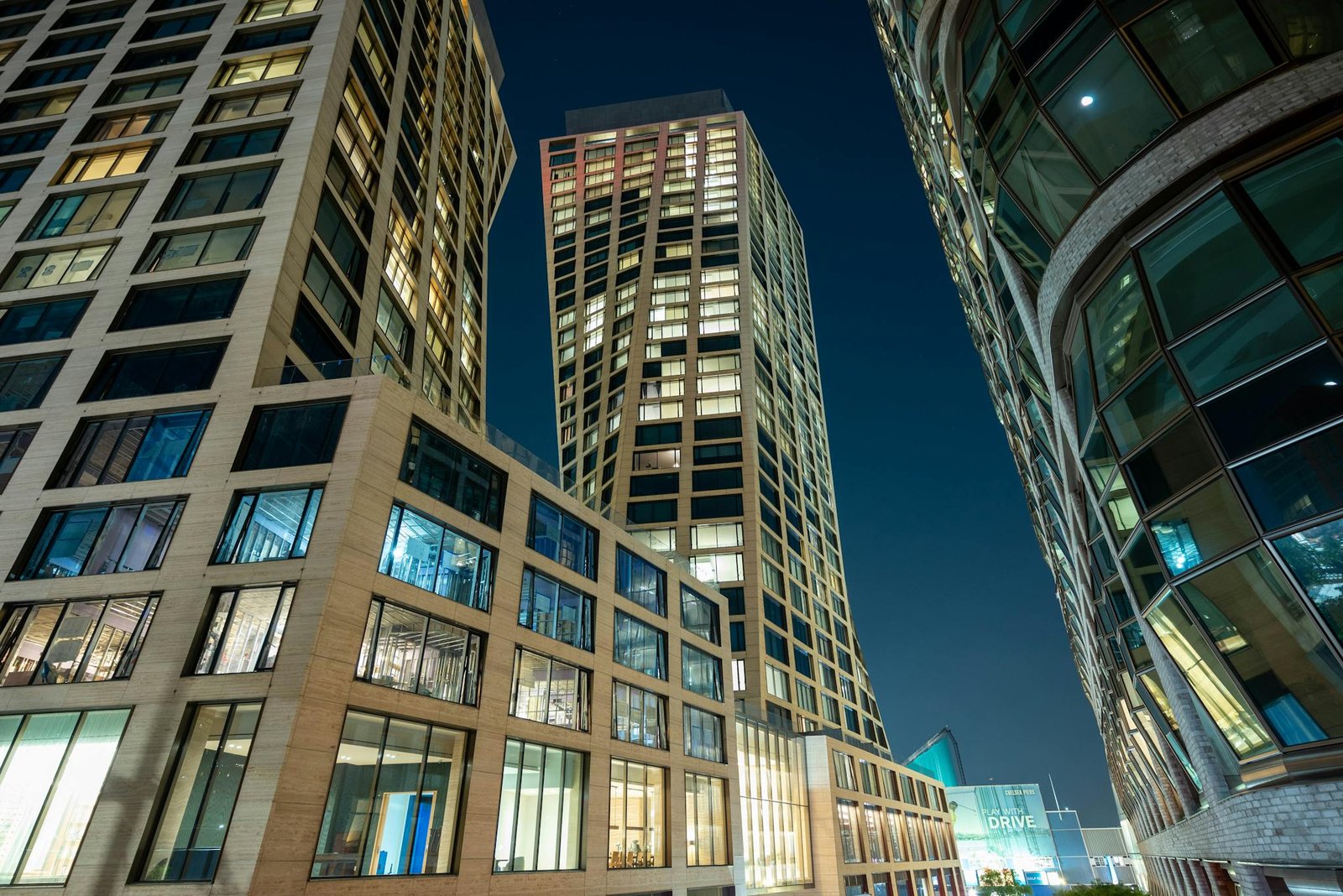Nighttime cityscape showcasing modern skyscrapers with illuminated windows.